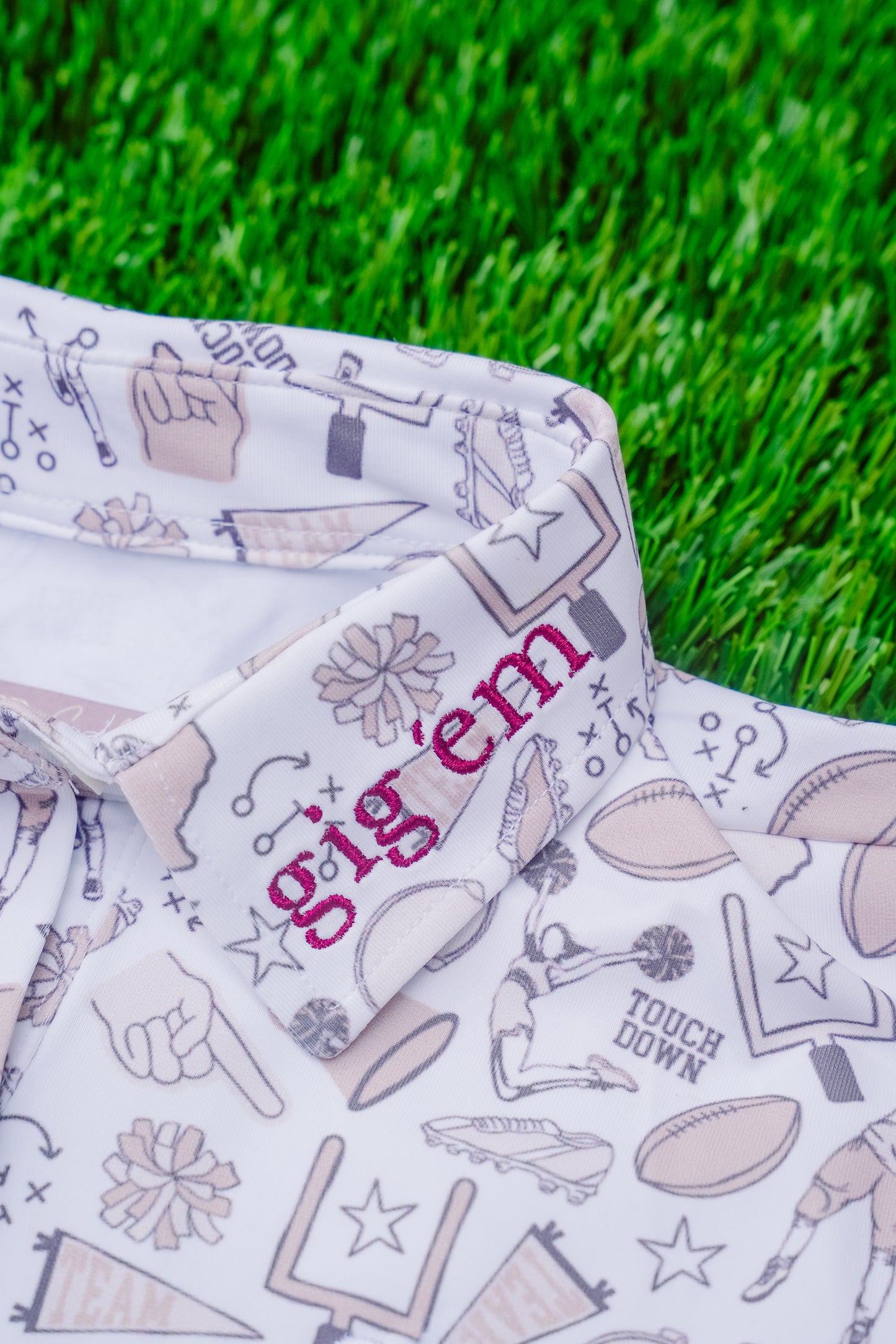 polo with sports-themed design on grass