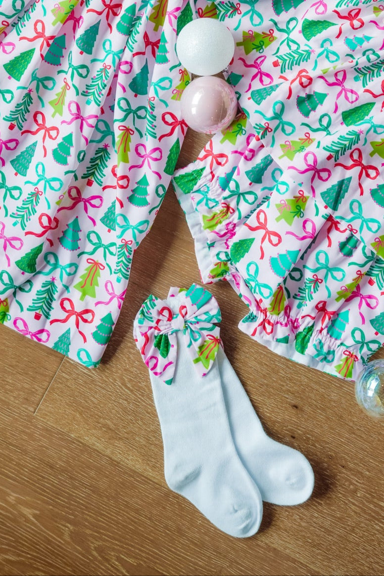 Baby leggings with festive pattern and white socks on a wooden surface