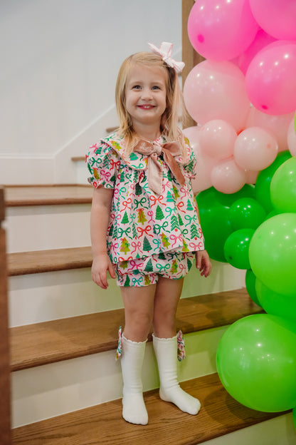 Young girl in a festive outfit standing next to balloons on a staircase