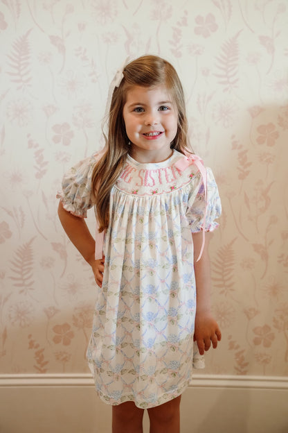 Young girl wearing a floral dress with a patterned background