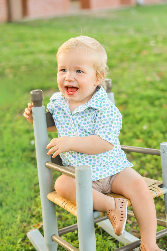 Boy wearing the Dapper Dog boys dog print polo shirt outdoors.