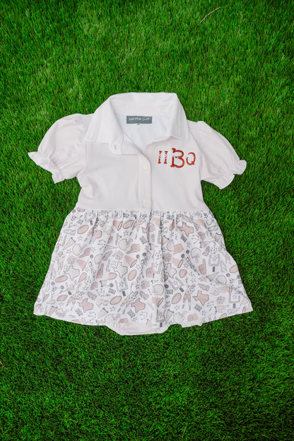 White dress with floral skirt and embroidery on a grass background