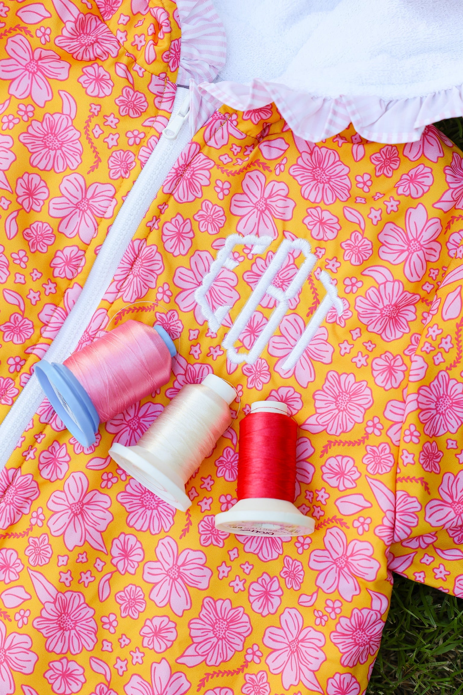 Close-up of a pink floral kids hooded towel poncho with personalized monogram embroidery and soft terry cotton lining.