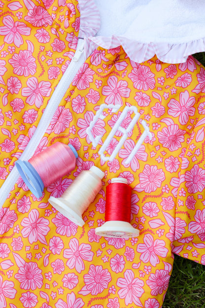 Close-up of a pink floral kids hooded towel poncho with personalized monogram embroidery and soft terry cotton lining.